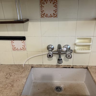 ברז כפול מעל כיור מטבח עם צינור לבן