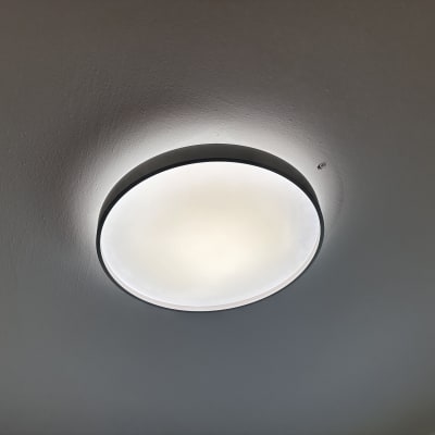 מנורת תקרה עגולה מוארת על תקרה לבנה