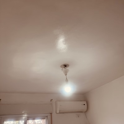 מנורה תלויה ותקרת חדר עם מזגן