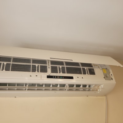 מזגן קיר עם מכסה פתוח ומסנן חשוף