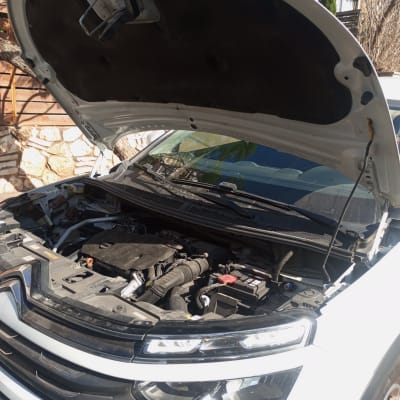 מכונית עם מכסה מנוע פתוח, מראה את המנוע והחלקים הפנימיים