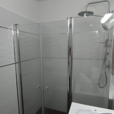 מקלחת עם דלתות זכוכית וברז גשם