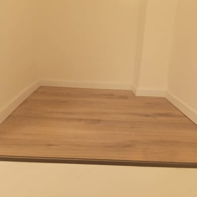 רצפת פרקט חדשה בחדר ריק עם קירות בהירים