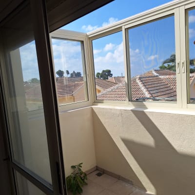 חלון אלומיניום במרפסת עם נוף לגגות