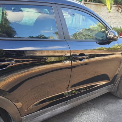 מכונית שחורה עם דלתות מבריקות וחישוקי גלגלים