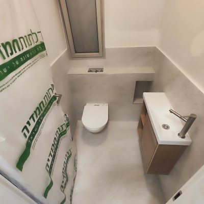 חדר שירותים משופץ עם כיור ואסלה חדשים