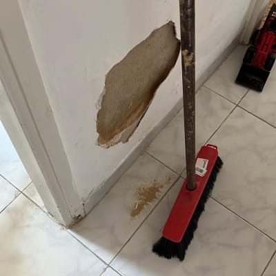 מטאטא ליד קיר עם חור ותיקון