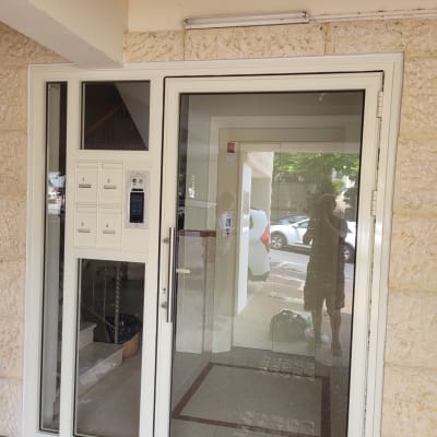 דלת אלומיניום עם חלון זכוכית ומסגרת לבנה