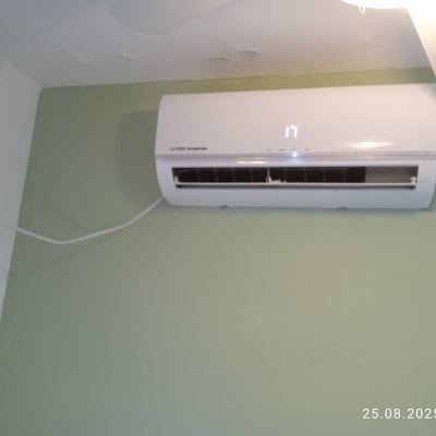 מזגן מותקן על קיר ירוק עם תצוגת טמפרטורה