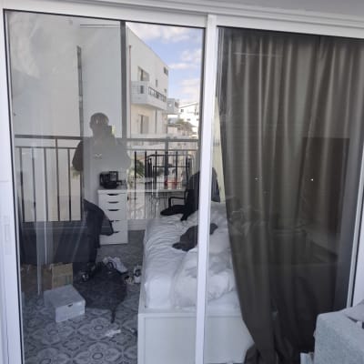 דלת זכוכית עם השתקפות של חדר שינה