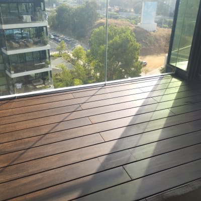 רצפת עץ במרפסת עם מעקה זכוכית