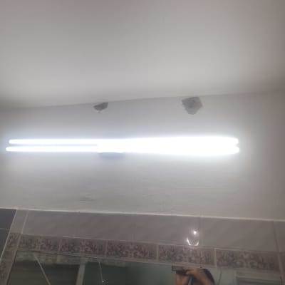 מנורת פלורסנט מותקנת על קיר עם חורים