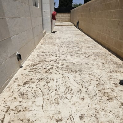 משטח בטון עם קיר לבנים וצינור מים אדום