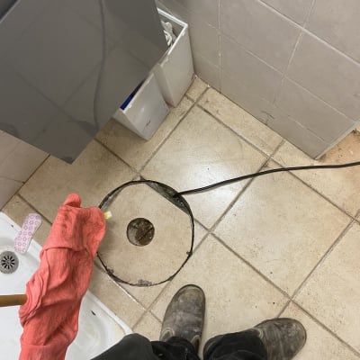 רצפת קרמיקה עם חור, מגבת אדומה וכלי עבודה