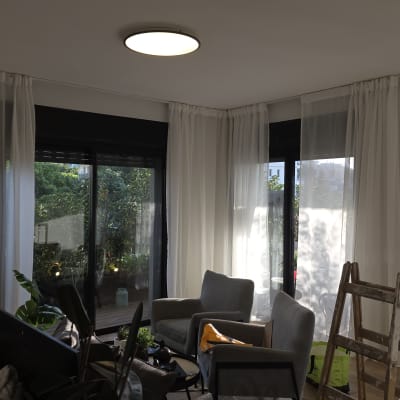 סולם וחלונות עם וילונות בחדר מואר