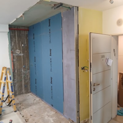 קיר גבס בבנייה עם דלת פתוחה וסולם