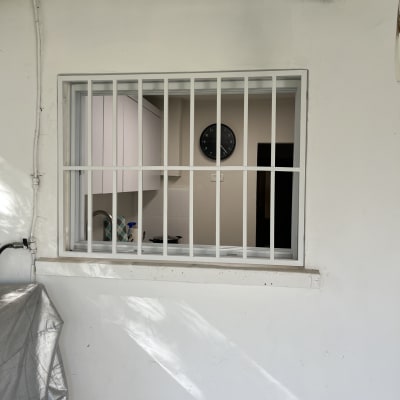 חלון עם סורגים לבנים על קיר חיצוני