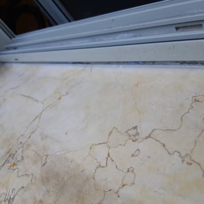 איטום חלון עם מסגרת מתכת על משטח שיש