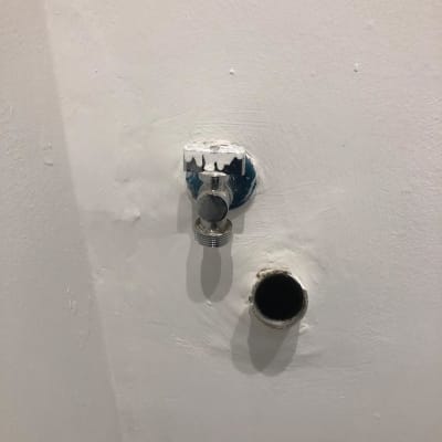 שסתום מים וצינור בקיר לבן