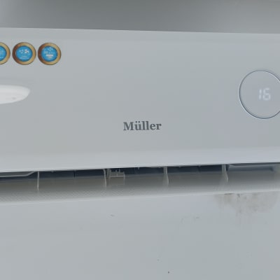 מזגן קיר לבן עם תצוגה דיגיטלית וטמפרטורה 16