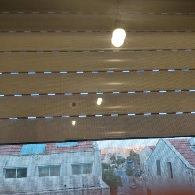 תריס גלילה מורד חלקית ורשת בחלון בית