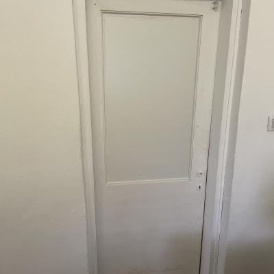 דלת עץ לבנה עם ידית וחור מנעול