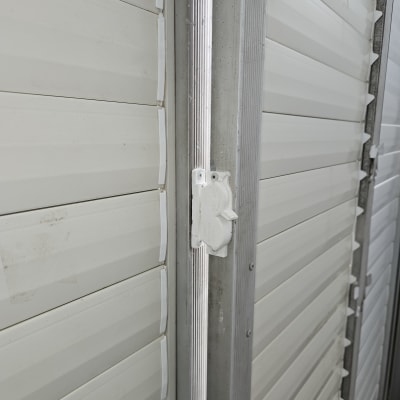 תריסים לבנים עם מסגרת מתכתית ומנגנון נעילה