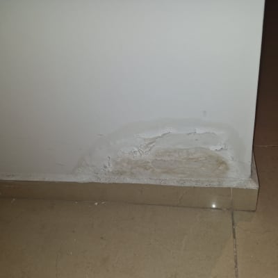 קיר עם סימני רטיבות ונזק בתחתית
