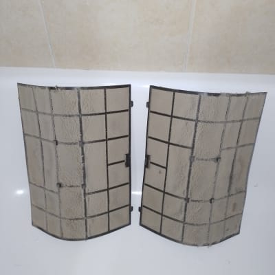 מסנני מזגן מלוכלכים מונחים על משטח לבן