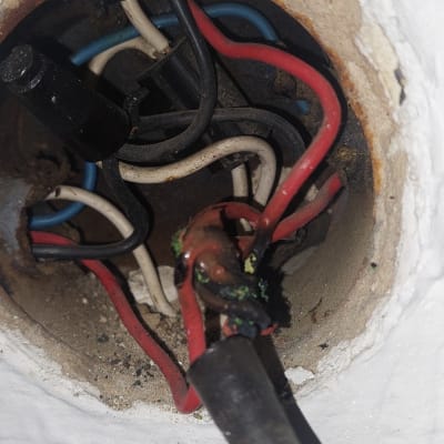 חוטי חשמל חשופים בתוך קיר