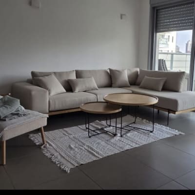 סלון עם ספה, שולחנות וכורסה ליד חלון גדול