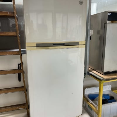 מקרר לבן עומד על בסיס עץ במעבדה