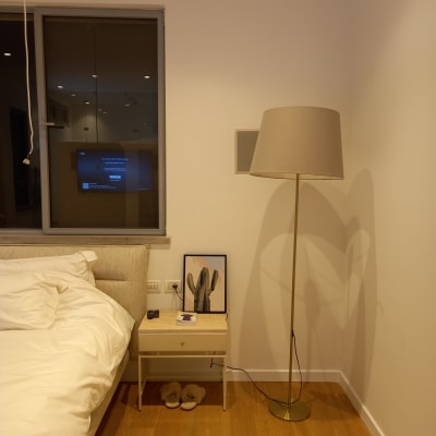 מנורת רצפה ליד מיטה עם שידה קטנה