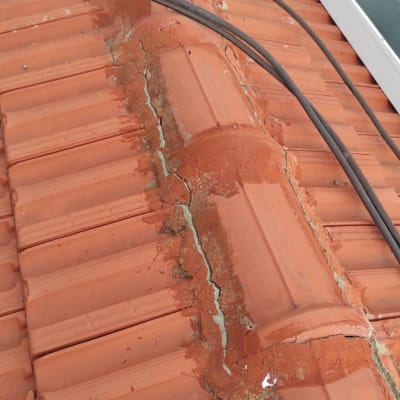רעפים כתומים עם סדקים וכבלים על הגג