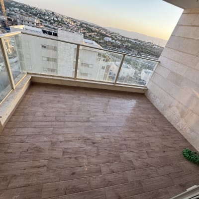 מרפסת נקייה עם רצפת עץ וצינור ירוק