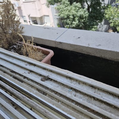 מסילות תריסים עם עציצים יבשים ברקע