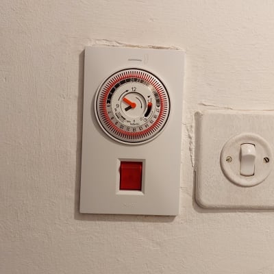 שעון טיימר חשמלי על קיר עם מתג