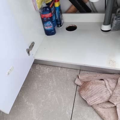 ארון פתוח עם מוצרי ניקוי וצינורות אינסטלציה