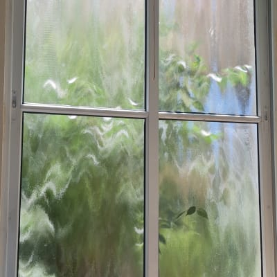 חלון עם זכוכית מטושטשת ושולחן עץ קטן