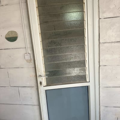 דלת זכוכית עם מסגרת לבנה על קיר לבן