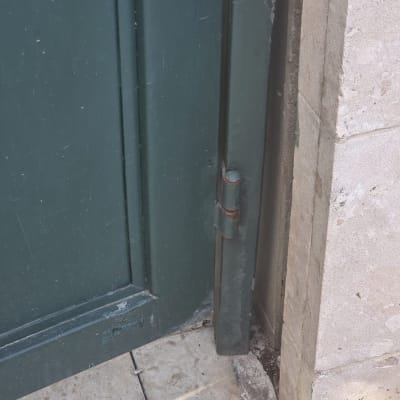 ציר שער מתכת על רצפת אבן