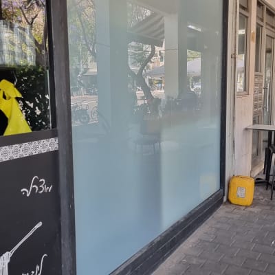 זכוכית חלבית עם השתקפות של עצים ואנשים