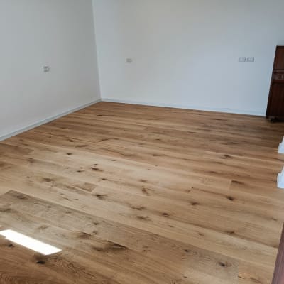 רצפת פרקט עץ בחדר ריק עם קירות לבנים