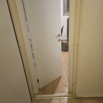 דלת לבנה פתוחה למחצה עם ידית כסופה