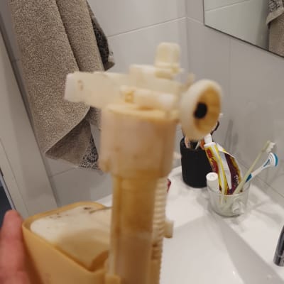 חלק פלסטיק צהוב של מערכת שירותים מוחזק ביד