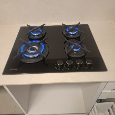 כיריים גז מזכוכית שחורה מותקנות בשיש עם מבערים דולקים