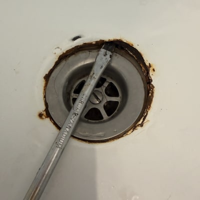 ניקוז חלוד עם כלי עבודה להסרת חלודה