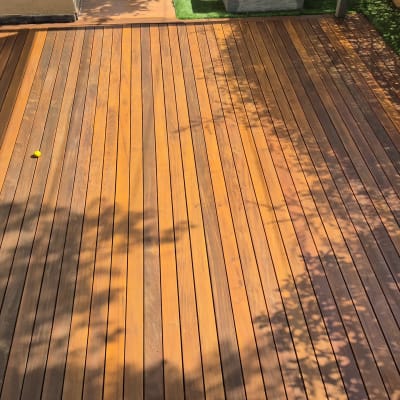 דק עץ חום עם צללים בגינה