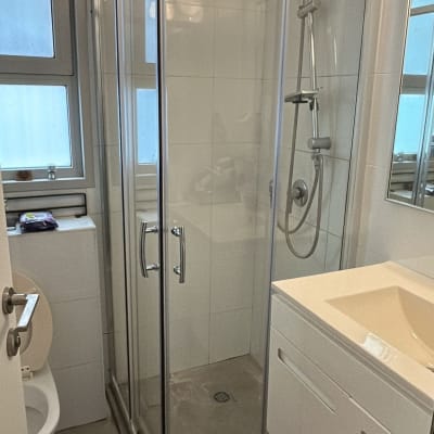 מקלחון זכוכית בחדר אמבטיה מודרני עם כיור ושירותים