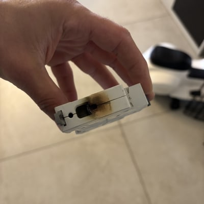 חלק חשמלי עם סימני שריפה מוחזק ביד